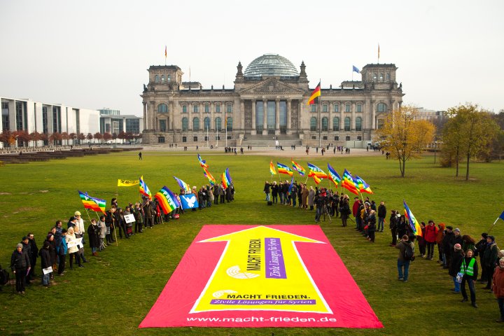 großes 100qm Banner mit dem Slogan "Macht Frieden" auf der Reichstagswiese vor dem Bundestag