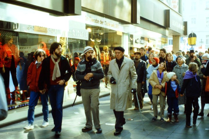 Heinrich Böll geht durch die Bonner Fußgängerzone gefolgt von vielen Menschen im Jahr 1981